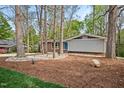 Charming home featuring mature trees, rock landscaping and a mix of brick and siding exterior at 1124 Hardimont Rd, Raleigh, NC 27609