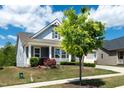 This charming home boasts a lovely front yard and a welcoming porch, perfect for enjoying the outdoors at 1208 Steinbeck Dr, Durham, NC 27703