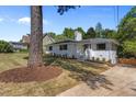 Beautiful white brick home with lush landscaping, mature trees, and a well-maintained lawn at 1310 Mayfair Rd, Raleigh, NC 27608