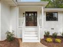 Inviting front porch with classic white railings, a stylish wood door, and manicured landscaping at 1310 Mayfair Rd, Raleigh, NC 27608