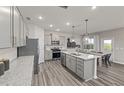 Modern kitchen featuring stainless steel appliances, gray cabinets, granite countertops, and wood flooring at 1311 Hollyview Ave, Durham, NC 27703