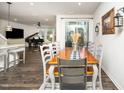 Dining room with wood table, seating for eight, sliding glass door to patio and views to the living room at 1403 Chipping Dr, Apex, NC 27502