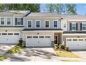 Charming townhome with attached garages, neutral siding, well manicured landscaping, and a concrete driveway at 1403 Chipping Dr, Apex, NC 27502