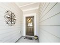 Inviting front door with a decorative wreath, a 'Welcome' mat, and an ornate wall decoration at 1403 Chipping Dr, Apex, NC 27502