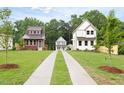 A long driveway leads to three attractive houses, surrounded by mature trees and greenery at 1448A Maplewood Dr, Durham, NC 27704