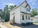 Two-story home with white siding, gray trim, covered entry, and a well-lit facade at 1448A Maplewood Dr, Durham, NC 27704