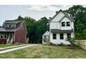 Three houses featuring different exterior colors: white, gray, and maroon sit in a grassy field at 1448A Maplewood Dr, Durham, NC 27704
