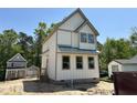 Charming new construction with light siding, black windows and neutral trim offers modern curb appeal at 1448A Maplewood Dr, Durham, NC 27704