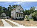 Charming two-story home features a white exterior, gray trim, and a cozy front porch at 1448A Maplewood Dr, Durham, NC 27704