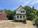 Charming two-story home features a white exterior, gray trim, and a cozy front porch at 1448A Maplewood Dr, Durham, NC 27704