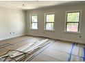 Bright, spacious room featuring three large windows providing ample natural light, ready for flooring at 1448A Maplewood Dr, Durham, NC 27704