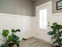 Inviting foyer boasts gray walls, white wainscoting, and stylish plants at 1517 Millrock Trl, Wendell, NC 27591