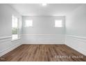 Spacious living room with wood floors, decorative wall trim, and large windows at 152 Cultivator Ct, Angier, NC 27501