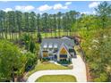 Gorgeous exterior view of the home featuring a landscaped lawn, circular driveway, and mature trees at 1616 Hunting Ridge Rd, Raleigh, NC 27615