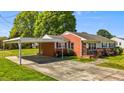 Brick home with carport, showcasing a well-maintained lawn and colorful landscaping at 1802 Prince Edward Dr, Elon, NC 27244