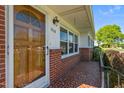 Welcoming front porch with patterned tile, brick accents, and a charming wooden front door at 1802 Prince Edward Dr, Elon, NC 27244