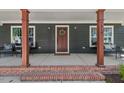 Charming covered front porch with seating, brick accents, and well-maintained landscaping provides a welcoming entrance at 2019 James St, Durham, NC 27707