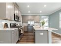 Modern kitchen with stainless steel appliances, white subway tile backsplash, and center island with breakfast bar at 226 Mahogany Run, Raleigh, NC 27610