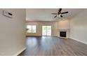 Bright living room featuring wood floors, a fireplace, ceiling fan, and access to the backyard at 2428 Diquedo Dr, Raleigh, NC 27604