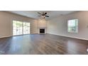 Spacious living room with wood floors, fireplace, ceiling fan, and sliding door to the backyard at 2428 Diquedo Dr, Raleigh, NC 27604