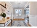 Bright foyer with hardwood floors, white trim, and a view into a dining room with coffered ceiling at 2437 Terri Creek Dr, Fuquay Varina, NC 27526