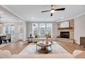 Comfortable living room with a stone fireplace, large windows, and a ceiling fan at 2437 Terri Creek Dr, Fuquay Varina, NC 27526