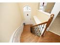 Entryway featuring a wooden staircase with metal railings and a diamond-patterned front door at 2507 Princewood St, Raleigh, NC 27612