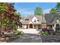 Elegant home exterior with a circular driveway, manicured landscaping, and a charming front entrance at 25303 Ludwell, Chapel Hill, NC 27517