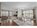 Bright dining room featuring a glass table, stylish seating, and an open layout connecting to the living area at 3100 Coachmans Way, Durham, NC 27705