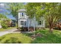 Two-story house featuring green shutters, bay window, landscaped yard, and proximity to mature shade trees at 3109 E Folkestone Pl, Raleigh, NC 27604