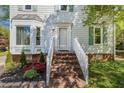 Welcoming home entrance with brick steps, white railings, and manicured landscaping at 3109 E Folkestone Pl, Raleigh, NC 27604