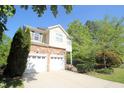 Stunning home with a stone facade, two-car garage, and concrete driveway, set amidst lush greenery at 3219 Ranbir Dr, Durham, NC 27713