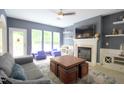 Spacious living room featuring a fireplace, ceiling fan, and backyard access through glass doors at 3219 Ranbir Dr, Durham, NC 27713
