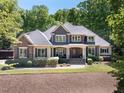 Daytime shot of a charming two-story home with stone and siding exterior and manicured landscaping at 3513 Forest Oaks Dr, Chapel Hill, NC 27514