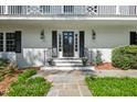 Elegant front entrance with black door, decorative sconces, and landscaped stone pathway at 3826 Regent Rd, Durham, NC 27707