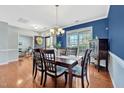 A dining room boasts hardwood floors, a dark wood table and six upholstered chairs at 421 Gooseberry Dr, Holly Springs, NC 27540