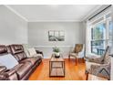 Comfortable living room featuring hardwood floors, a leather sofa, and lots of natural light at 421 Gooseberry Dr, Holly Springs, NC 27540