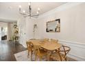 Dining area with wood table and chairs, decorative mirror, and elegant chandelier at 4240 Camden Woods Ct, Raleigh, NC 27612