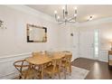 Inviting dining room with modern light fixture, hardwood floors, and an ornate decorative mirror at 4240 Camden Woods Ct, Raleigh, NC 27612