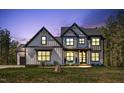 Charming two-story home with a covered front porch, showcasing its inviting curb appeal at dusk at 45 Hamilton Way, Youngsville, NC 27596