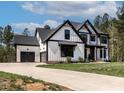 Beautiful modern farmhouse exterior, showcasing white siding and a long driveway at 45 Hamilton Way, Youngsville, NC 27596
