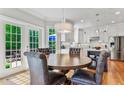 Inviting dining area with a round table, tufted chairs, and natural light from the adjacent patio at 4513 Touchstone Forest Rd, Raleigh, NC 27612