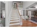 Elegant foyer featuring a staircase with white railing and hardwood floors, leading to an open layout at 4513 Touchstone Forest Rd, Raleigh, NC 27612