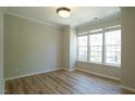 Bright bedroom with LVP flooring, crown moulding and multiple windows at 4517 Pale Moss Dr, Raleigh, NC 27606