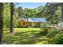 Inviting wood-sided home with a well-maintained lawn and blooming flowers, framed by mature trees at 5204 William And Mary, Raleigh, NC 27616