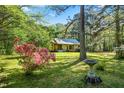 Quaint home with stone accents and a well-manicured lawn, surrounded by mature trees and azaleas at 5204 William And Mary, Raleigh, NC 27616
