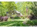 Classic brick home with American flag, manicured lawn and mature trees at 5912 Weather Rock Ct, Raleigh, NC 27613