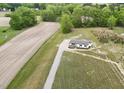 Aerial view of a single story house on a large lot with a long driveway and adjacent farm fields at 66 Privette Way, Zebulon, NC 27597