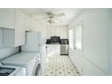 Well-lit kitchen featuring white cabinets, modern appliances, and a classic tile floor at 704 N King Charles Rd, Raleigh, NC 27610