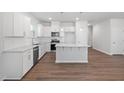 Modern kitchen featuring white cabinets, granite countertops, stainless steel appliances, and hardwood flooring at 728 Ben Ledi Ct, Raleigh, NC 27603